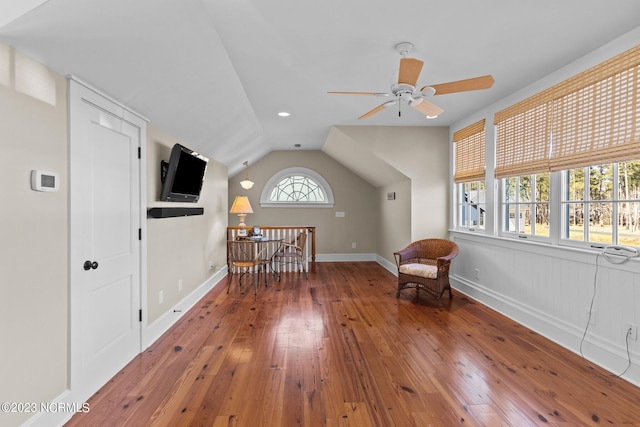 unfurnished room with lofted ceiling, a healthy amount of sunlight, ceiling fan, and dark hardwood / wood-style flooring