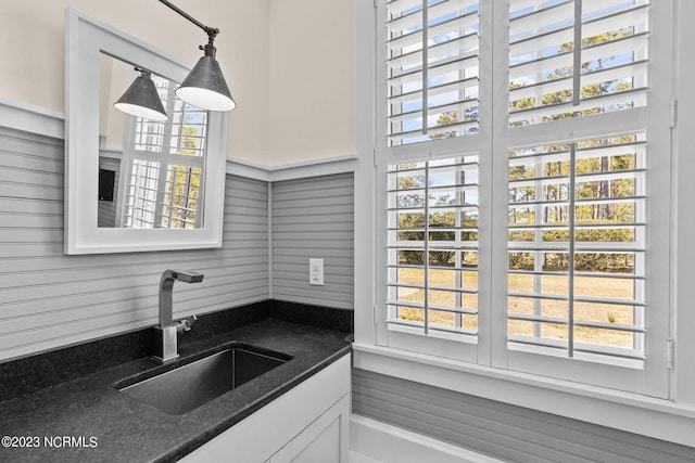 kitchen featuring a healthy amount of sunlight, hanging light fixtures, and white cabinetry