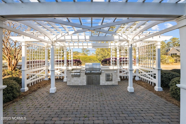 view of terrace featuring a pergola, an outdoor kitchen, and area for grilling