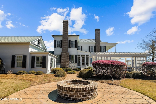 back of house featuring a yard, an outdoor fire pit, and a patio