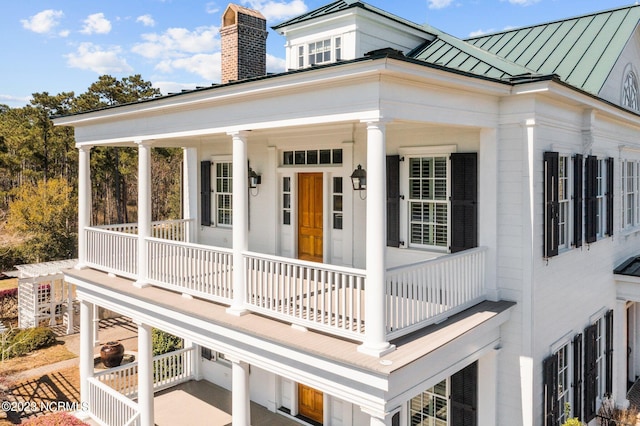 rear view of property featuring covered porch