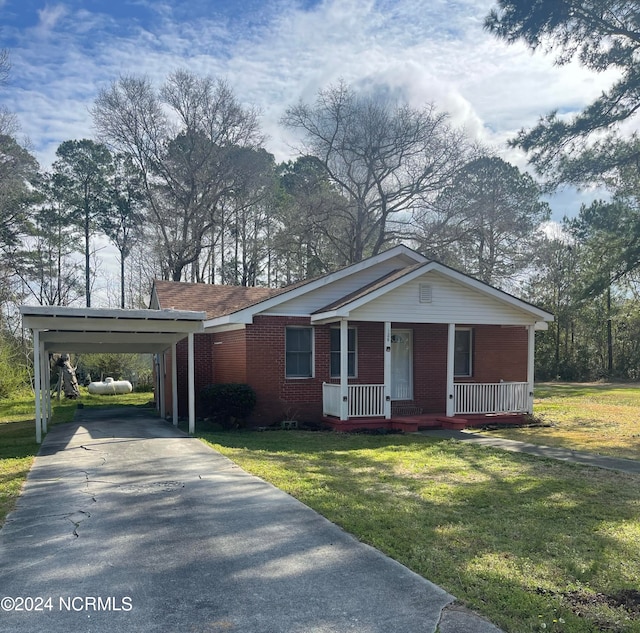 single story home featuring covered porch, a front yard, and a carport