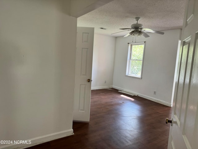 unfurnished room featuring a textured ceiling, ceiling fan, and dark hardwood / wood-style flooring