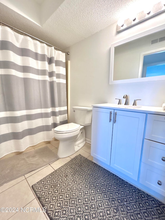 bathroom featuring a textured ceiling, vanity, toilet, and tile flooring