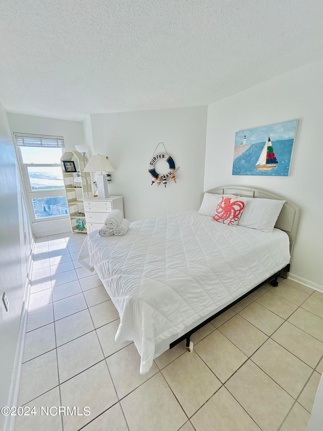 tiled bedroom with a textured ceiling