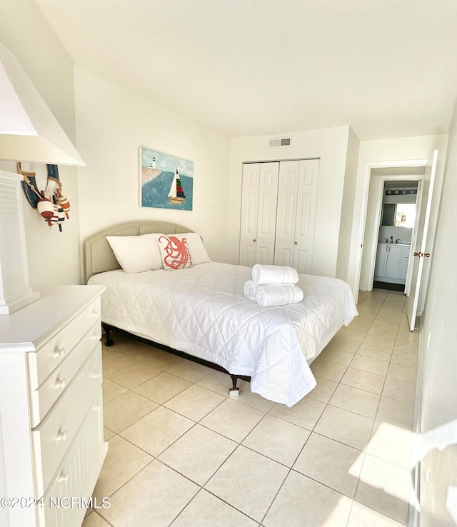 bedroom featuring a closet and light tile floors