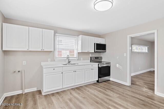 kitchen with white cabinetry, light hardwood / wood-style flooring, sink, and stainless steel appliances