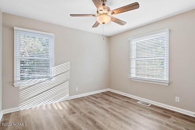 empty room with ceiling fan and dark hardwood / wood-style floors