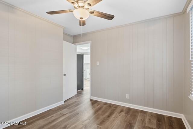 unfurnished room with crown molding, dark hardwood / wood-style floors, and ceiling fan