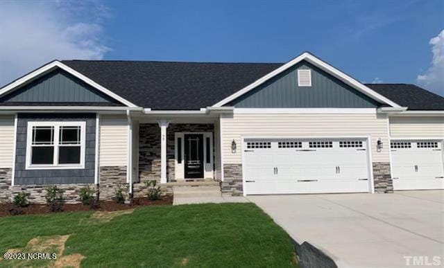 craftsman house with a garage and a front yard