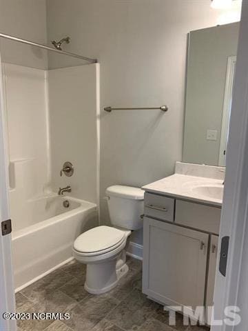 full bathroom featuring toilet, tile floors, vanity, and washtub / shower combination