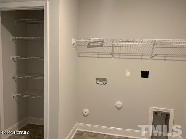 laundry area featuring dark tile flooring and hookup for a gas dryer