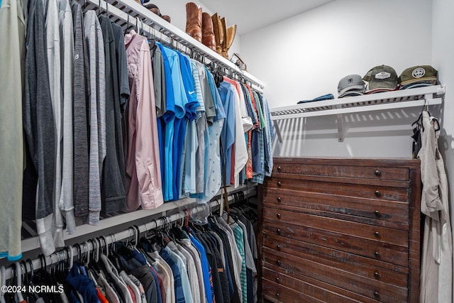 walk in closet featuring dark colored carpet