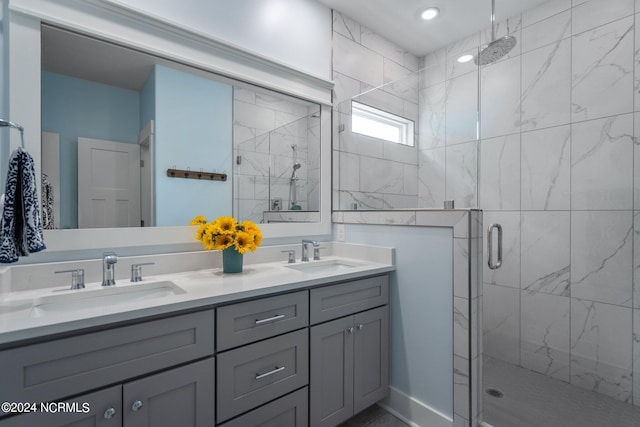 bathroom featuring a shower with door and double sink vanity