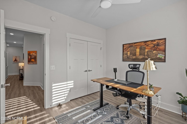 home office with ceiling fan and dark wood-type flooring