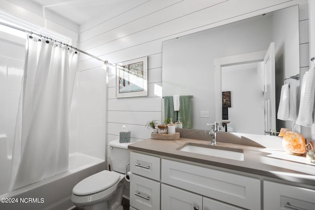 full bathroom featuring toilet, vanity with extensive cabinet space, wood walls, and shower / tub combo