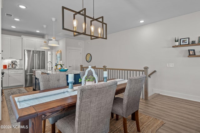 dining space with an inviting chandelier and light wood-type flooring