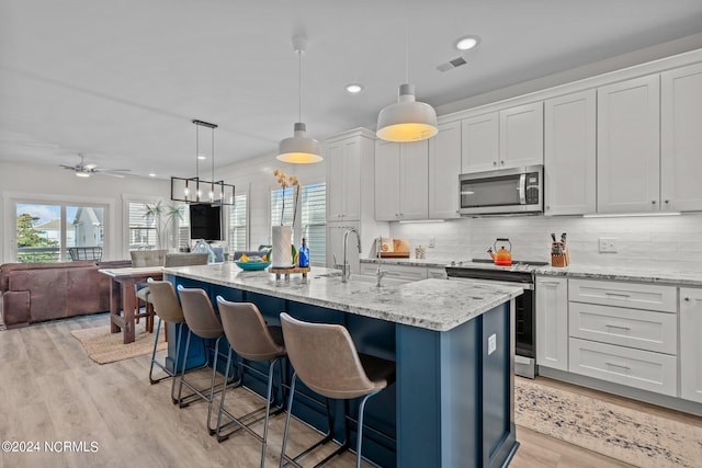 kitchen featuring white cabinets, an island with sink, and stainless steel appliances