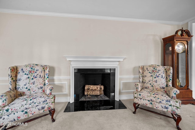 sitting room featuring ornamental molding and dark colored carpet