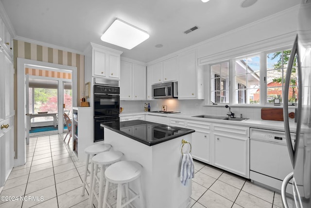 kitchen featuring sink, plenty of natural light, a kitchen island, stainless steel appliances, and white cabinetry