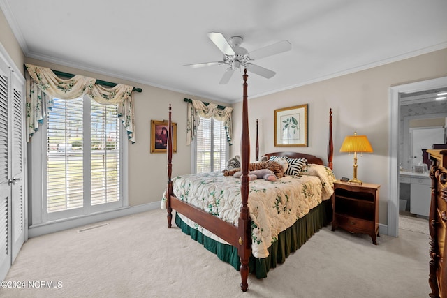 bedroom with ensuite bath, crown molding, ceiling fan, and light colored carpet