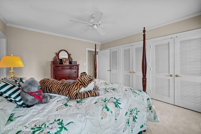 bedroom featuring light carpet, two closets, ceiling fan, and crown molding