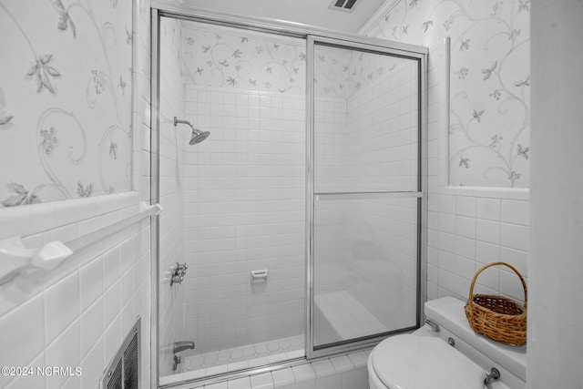 bathroom featuring tile walls and toilet