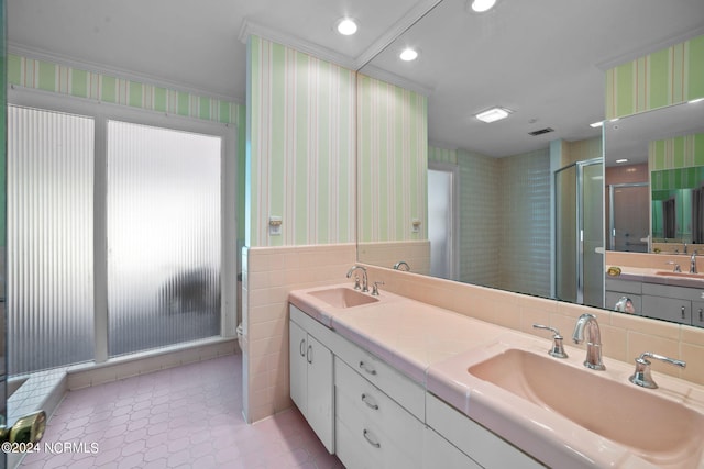 bathroom with tile walls, tile floors, a shower with door, tasteful backsplash, and double vanity