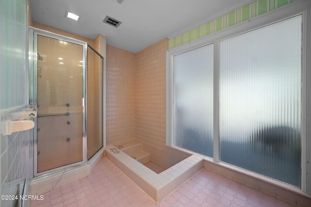 bathroom featuring an enclosed shower and tile flooring