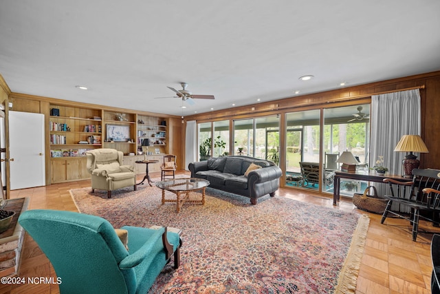 living room featuring plenty of natural light, ceiling fan, and built in shelves