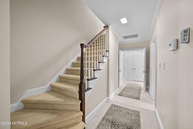 stairway featuring light carpet and ornamental molding