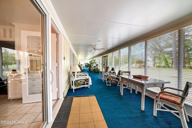 sunroom with a baseboard radiator and ceiling fan