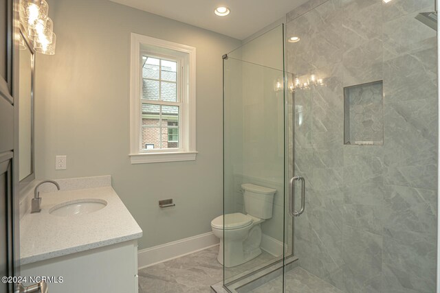 bathroom featuring tile patterned floors, toilet, an enclosed shower, and vanity