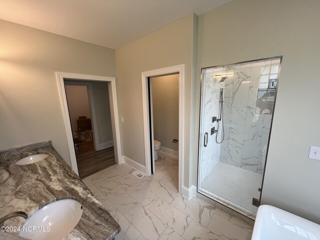 bathroom featuring toilet, vanity, walk in shower, and tile patterned floors