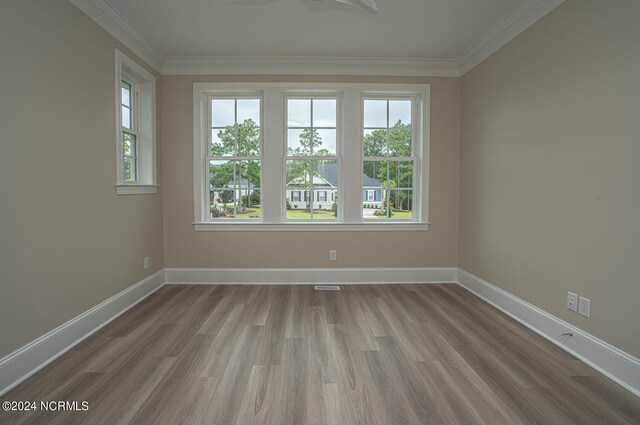 spare room featuring crown molding and hardwood / wood-style floors