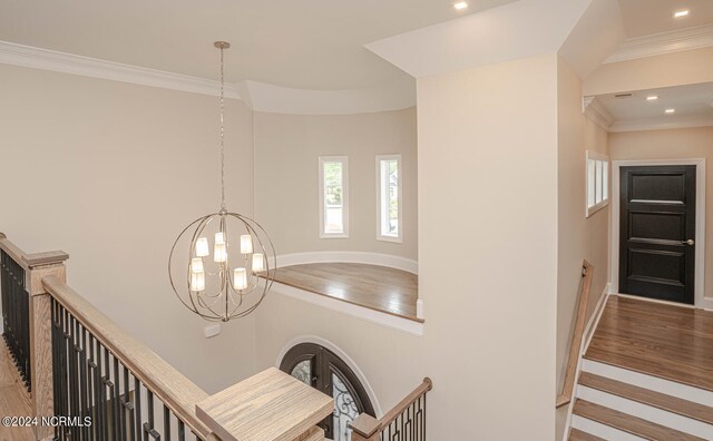 room details featuring a notable chandelier, crown molding, and wood-type flooring