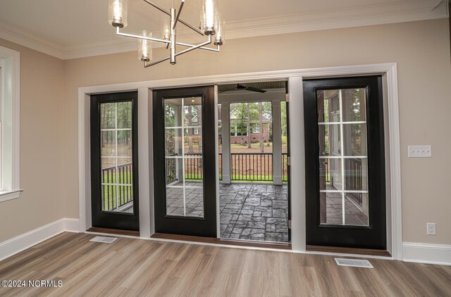 doorway featuring hardwood / wood-style flooring, a notable chandelier, and ornamental molding