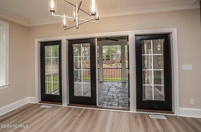 entryway with ornamental molding, wood finished floors, and visible vents