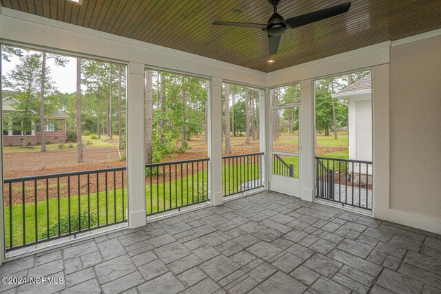 unfurnished sunroom featuring plenty of natural light, ceiling fan, and wooden ceiling