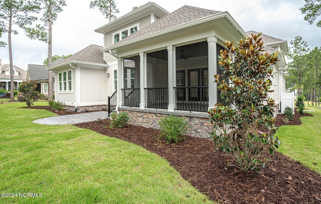 back of property featuring a yard and a sunroom