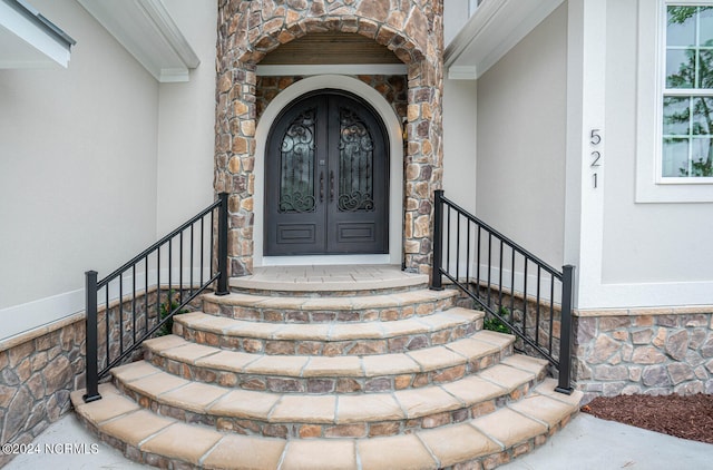 doorway to property featuring stone siding and stucco siding