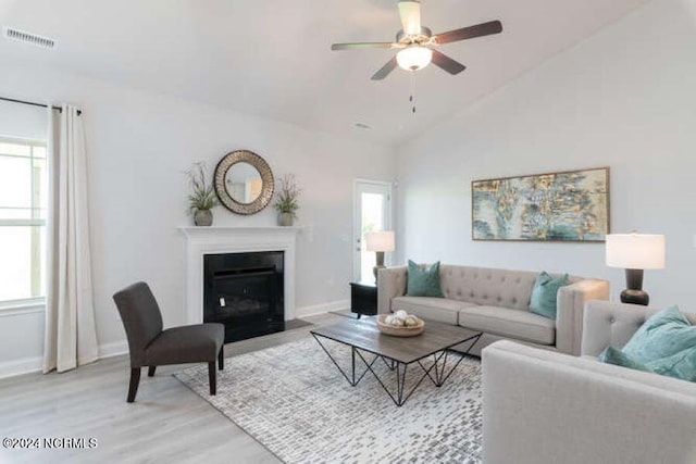 living room with wood-type flooring, plenty of natural light, high vaulted ceiling, and ceiling fan