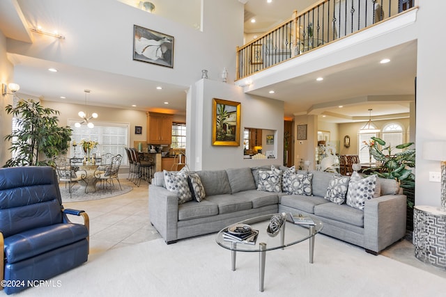 carpeted living room with an inviting chandelier, ornamental molding, and a towering ceiling