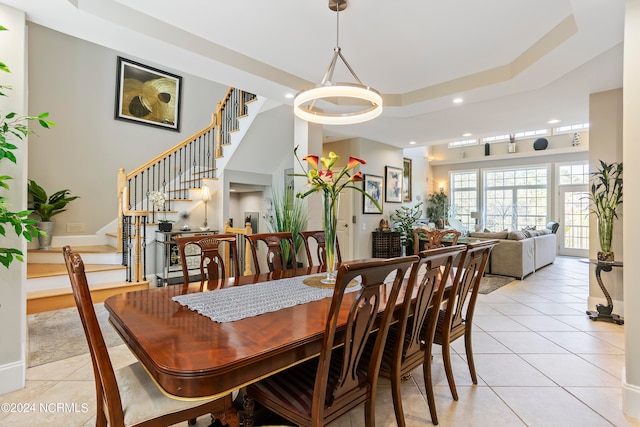 tiled dining room with a tray ceiling