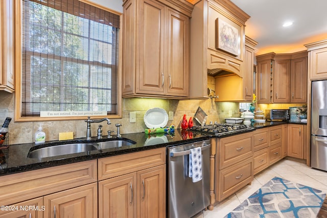 kitchen with dark stone counters, tasteful backsplash, light tile floors, and appliances with stainless steel finishes