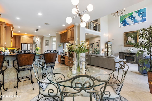 dining room featuring light tile floors, ornamental molding, and a notable chandelier