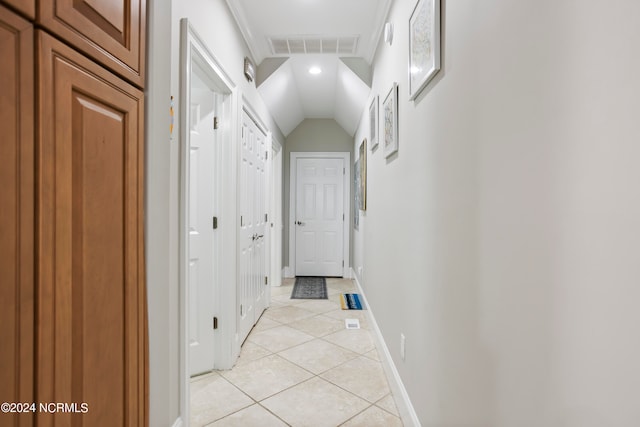 hall with vaulted ceiling and light tile floors