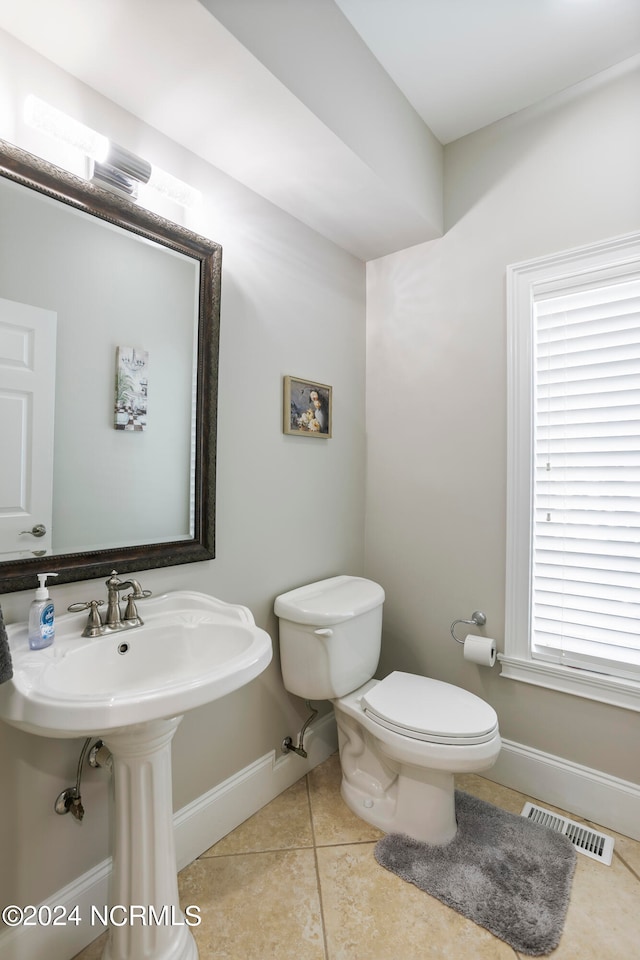 bathroom featuring tile flooring and toilet