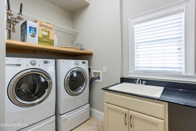 washroom featuring light tile flooring, a healthy amount of sunlight, independent washer and dryer, and sink