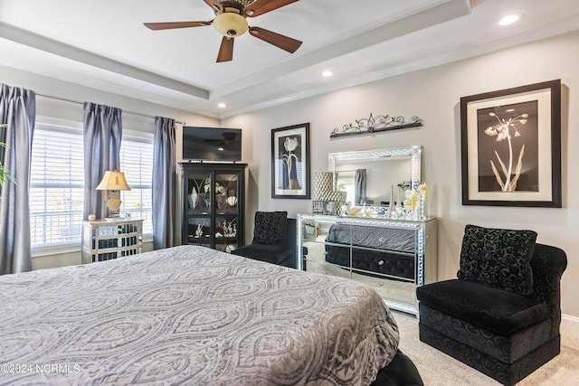 bedroom featuring ceiling fan, a tray ceiling, and light colored carpet